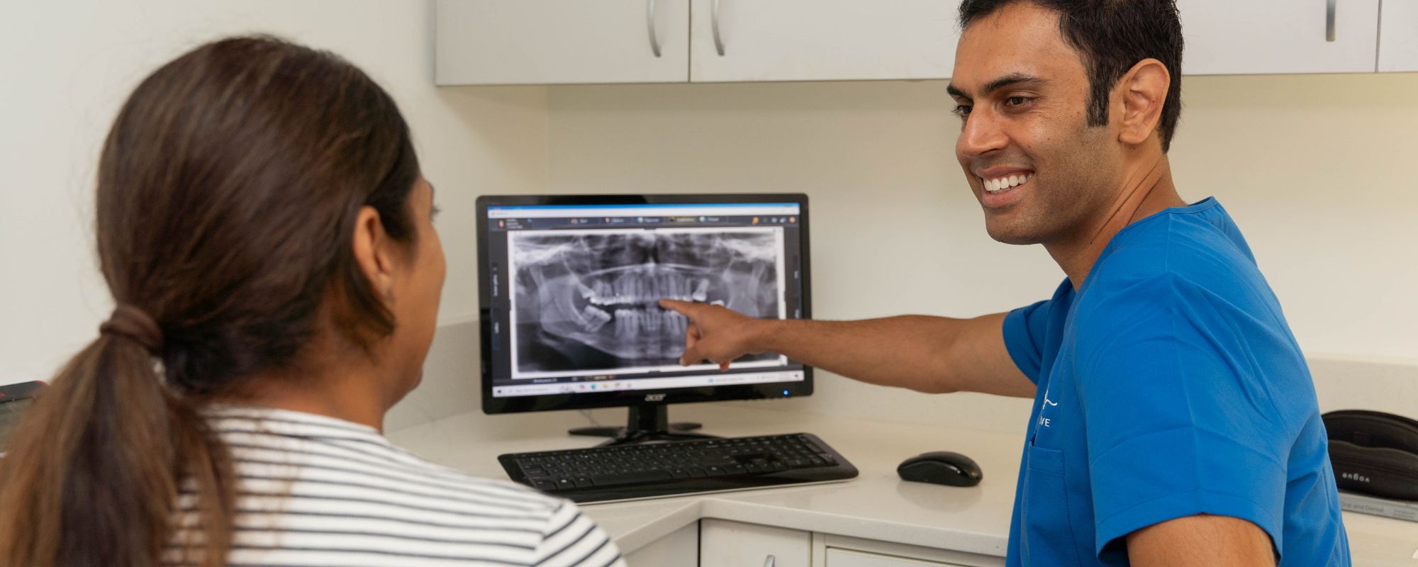 Dr Sundeep Suaan going through an x-ray with a patient at Hallett Cove Smiles